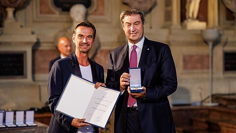 Ministerpräsident Markus Söder (CSU, r) ehrt Moderator Florian Silbereisen mit dem Bayerischen Verdienstorden.