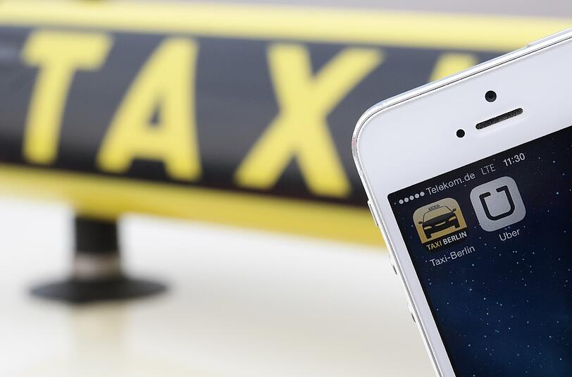 Die Handy-Apps "Uber" und "Taxi Berlin" auf einem Smartphone.