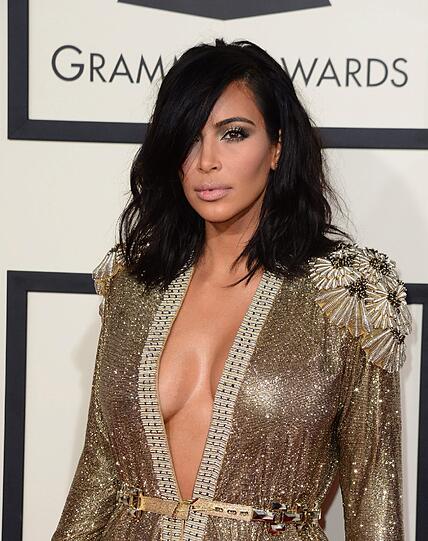 Kim Kardashian im goldenen, tief ausgeschnittenen Kleid.