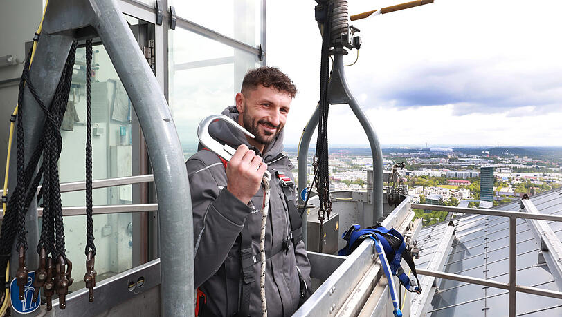 Sicherheit hat oberste Priorität. "Eigentlich darf sich nie Routine einschleichen", sagt Benjamin Bajrovic im Krankorb auf den Highlight Towers. Im Hintergrund: großartiger Ausblick Richtung Allianz Arena.