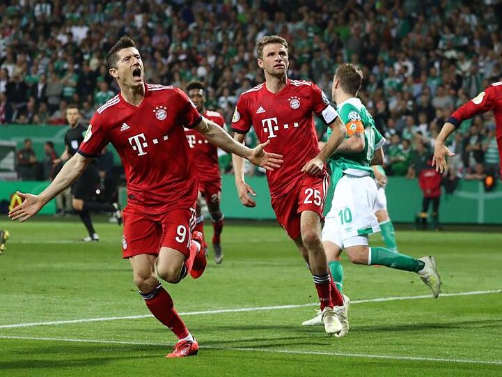Thomas Müller (M) feiert mit Elfmeterschütze Robert Lewandowski (l) das 3:2 in Bremen.