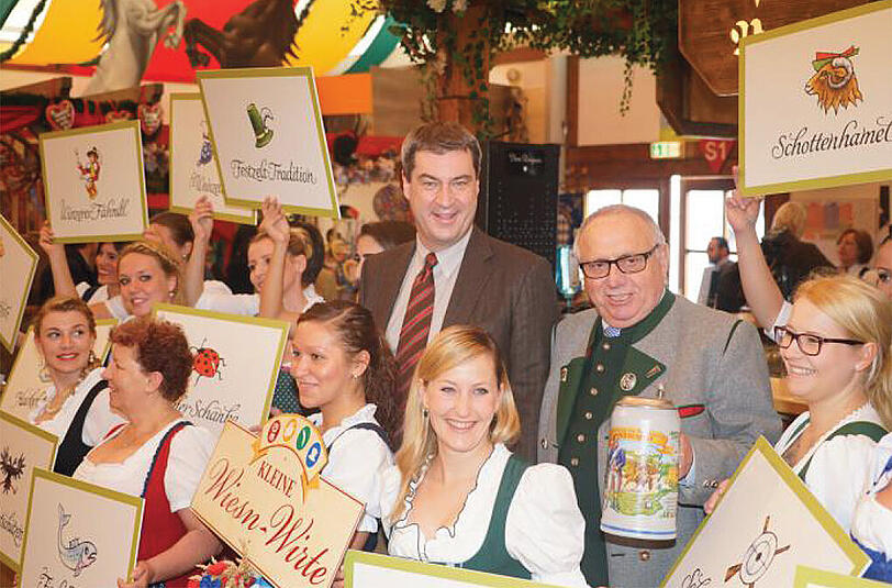 So lässt es sich aushalten: Finanzminister Markus Söder (li.) und Wirtesprecher Toni Roiderer in mitten lauter strahlender Volksfestbedienungen.