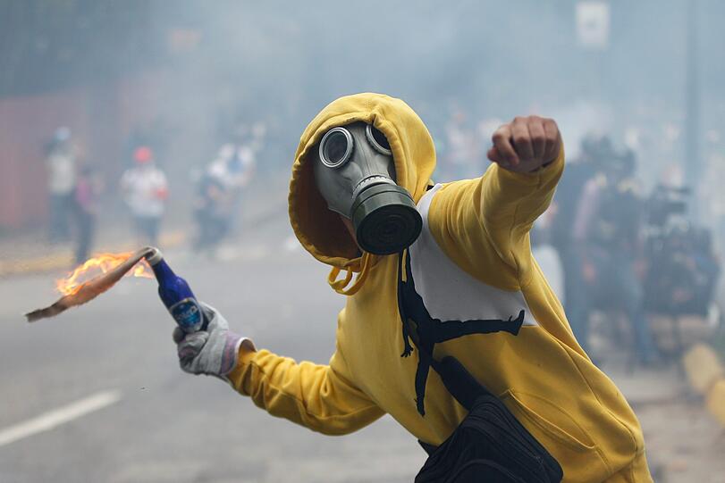 01.05.2017: Ausschreitungen am 1. Mai in Venezuela: Ein Mann wirft bei einer Demonstration zum Tag der Arbeit in Caracas einen Molotow-Cocktail in Richtung der Polizei.