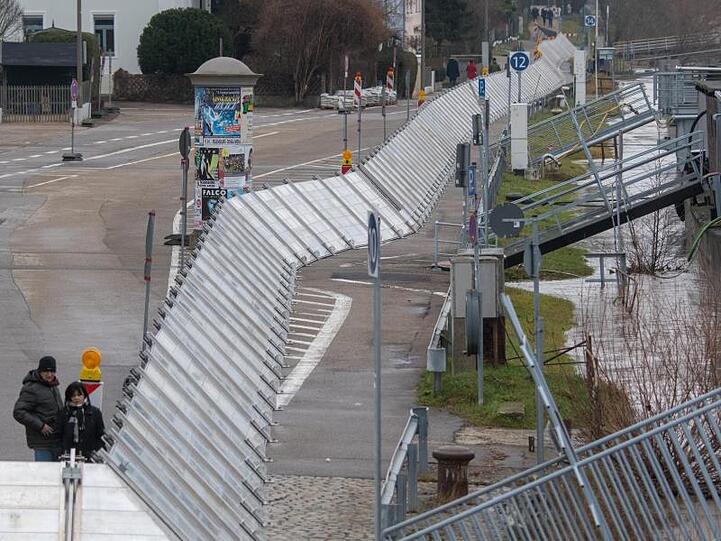 Schutzwände stehen in Regensburg am Ufer der Hochwasser führenden Donau. Foto: Armin Weigel/Archiv