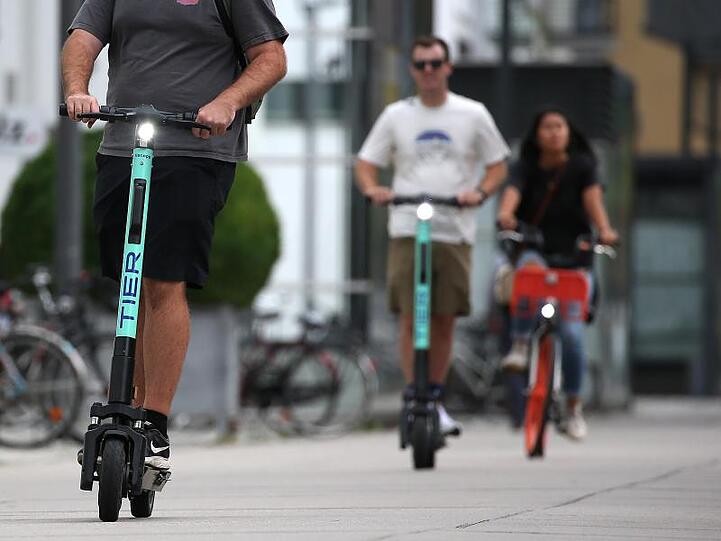Touristen fahren mit E-Tretrollern durch Köln.