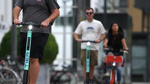 Touristen fahren mit E-Tretrollern durch Köln.
