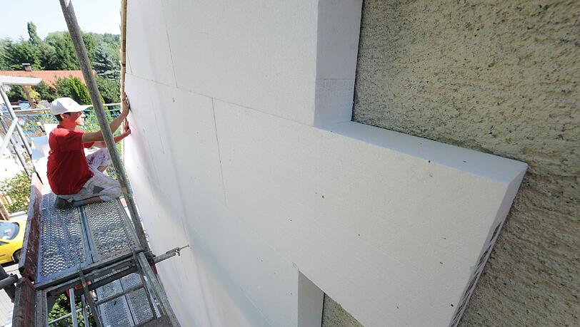 Ein Arbeiter befestigt eine Styroporplatte zur Wärmedämmung an einer Hausfassade. (Archivbild) Ein Arbeiter befestigt eine Styroporplatte zur Wärmedämmung an einer Hausfassade. (Archivbild)