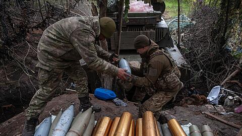 Ukrainische Soldaten bereiten Haubitzengranaten vor.