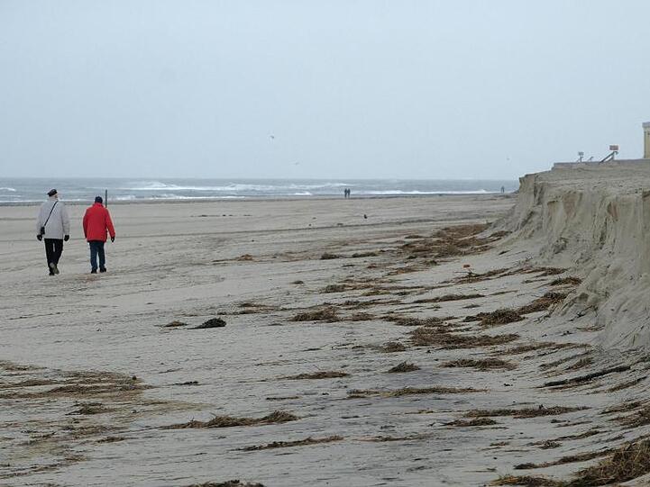 Nur noch wenig Sand da: Besucher spazieren an der Abbruchkante des Strandes von Wangerooge.