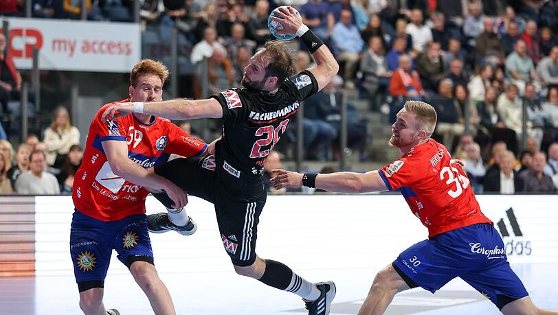 Nico Büdel (M) vom HC Erlangen kämpft sich an Lukas Stutzke (l) und Tom Kare Nikolaisen vom Bergischen HC vorbei.
