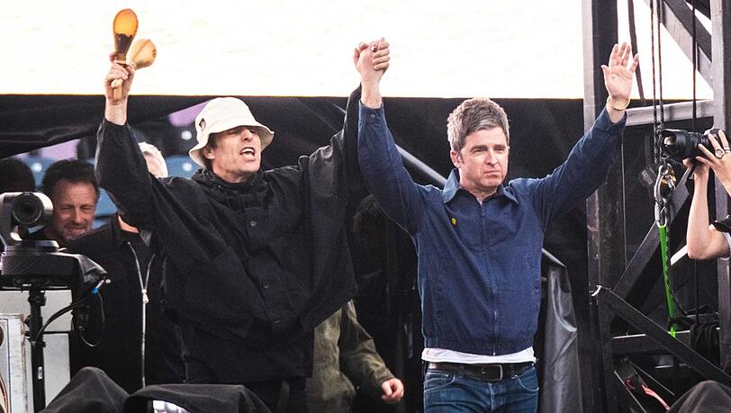 Liam und Noel Gallagher triumphierend auf der Bühne. Liam und Noel Gallagher triumphierend auf der Bühne.