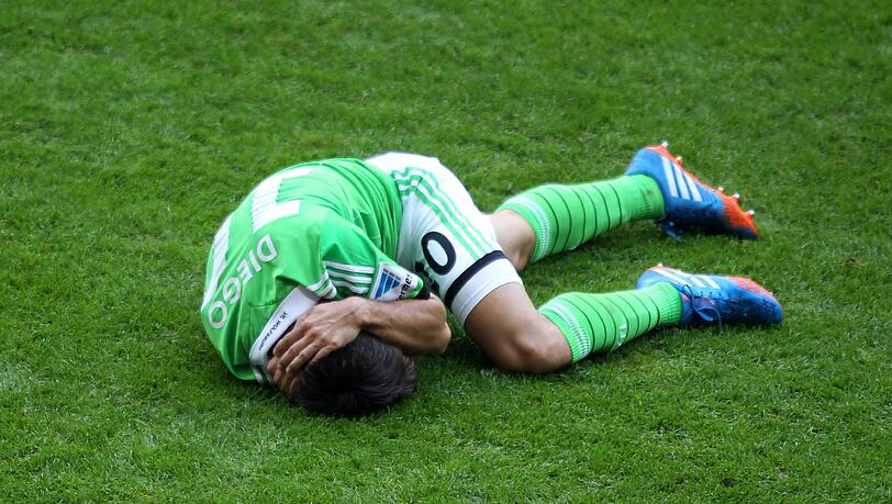 Nach Schweinsteigers Attacke windet sich Wolfsburgs Diego auf dem Boden. Foto: sampics/Augenklick
