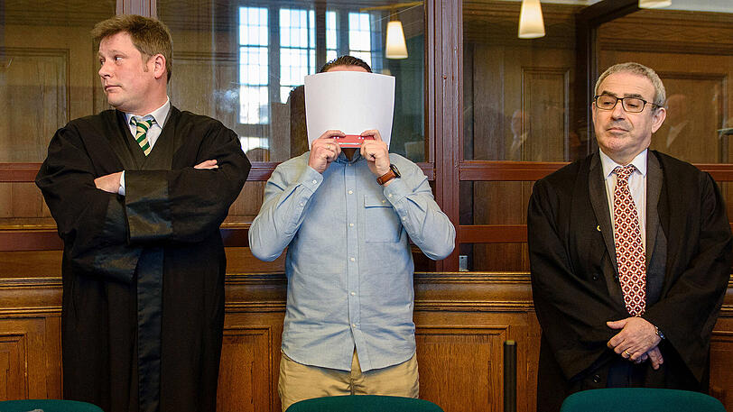 Der Angeklagte Hamdi H. steht in Berlin in einem Gerichtssaal des Landgerichtes Berlin zwischen seinen Anwälten und hält sich eine Akte vor das Gesicht. Zusammen mit einem Mitangeklagten hat er sich der Anklage zufolge ein illegales Rennen auf dem Kurfürstendamm geliefert und einen Unfall mit einem unbeteiligten Fahrzeug verursacht. Beide Angeklagten wurden wegen Mordes verurteilt.