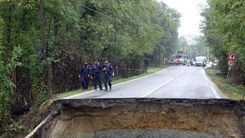 Carabinieri begutachten eine durch heftige Regenfälle zerstörte Straße. Carabinieri begutachten eine durch heftige Regenfälle zerstörte Straße.