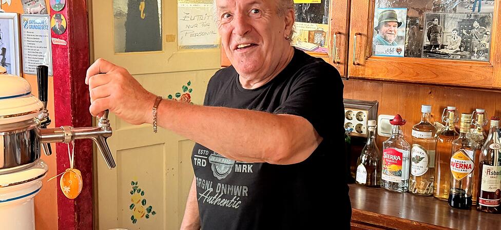 Wimpel,
Kunstblumen, Starfotos und Spr&uuml;che: St&uuml;berl-Urgestein Herbi am Zapfhahn im Sendlinger St&uuml;berl &bdquo;Bei Dagmars Herbi&ldquo;.