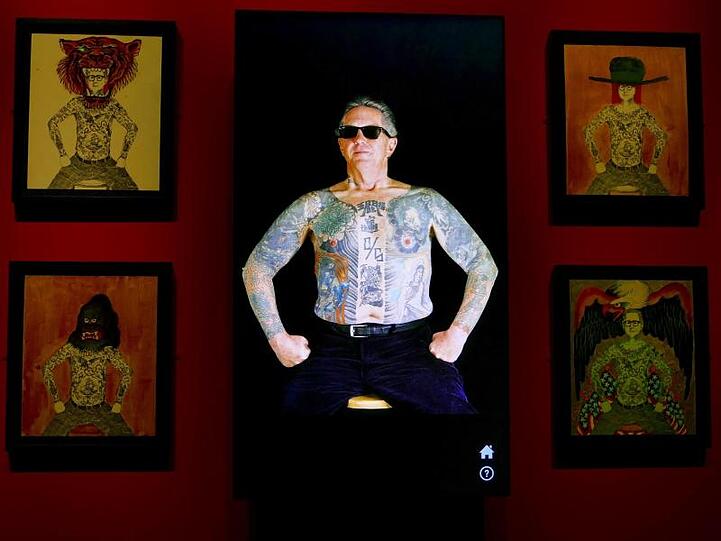 Eine Installation zeigt Tattoo-Künstler Ed Hardy auf einem Bildschirm im Fine Arts Museum in der Ausstellung "Ed Hardy: Deeper than Skin" und seine Tätowierungen am Oberkörper.