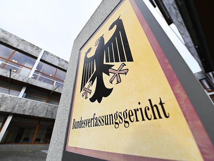 Ein Hinweisschild mit Bundesadler und dem Schriftzug "Bundesverfassungsgericht". Foto: Uli Deck/dpa/Archivbild
