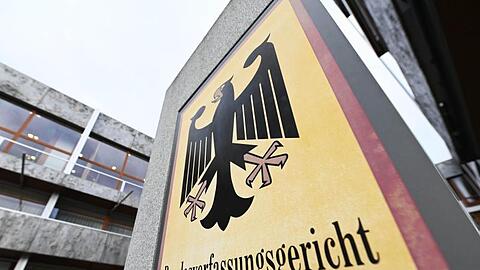 Ein Hinweisschild mit Bundesadler und dem Schriftzug "Bundesverfassungsgericht". Foto: Uli Deck/dpa/Archivbild