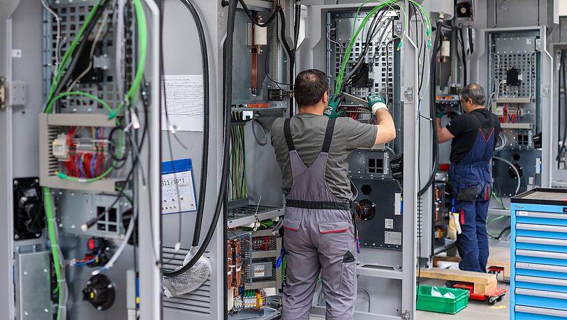Mitarbeiter verdrahten Ladesysteme von Siemens für Elektroautos.