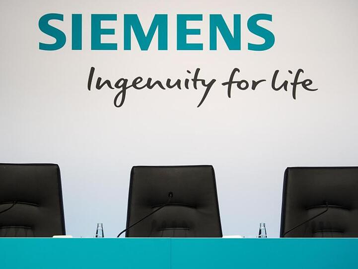 Das Siemens Logo ist vor einer Pressekonferenz auf dem Podium in der Siemenszentrale zu sehen. Foto: Sven Hoppe