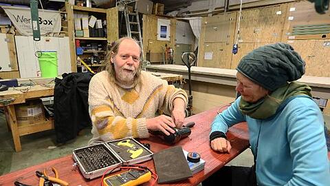 Hobbybastler Uwe Schrott mit einem kaputten Föhn, den eine Münchnerin ins Repair Café mitgebracht hat. Bald soll er wieder funktionieren.