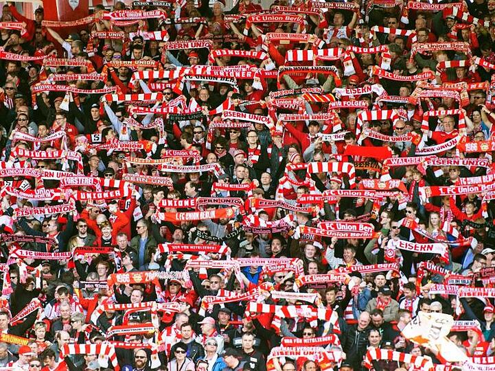 Berliner Fans halten ihre Schals hoch. Foto: Christophe Gateau/dpa/Archivbild