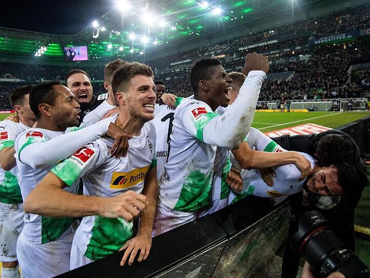 Die Gladbacher Spieler jubeln nach dem Treffer zum 2:1 durch Ramy Bensebaini (r).