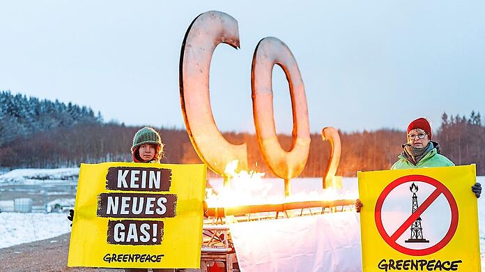 Aktivisten von Greenpeace protestieren mit einem brennenden CO2-Zeichen gegen geplante Gasbohrungen in der Nähe von Reichling in Oberbayern.