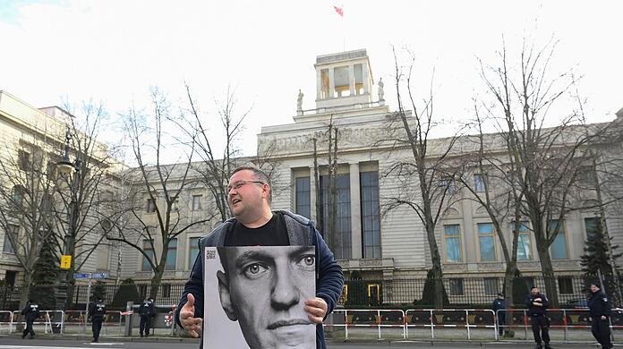 Ein Aktivist steht mit einem Plakat von Kremlkritiker Alexej Nawalny vor der russischen Botschaft in Berlin und protestiert.