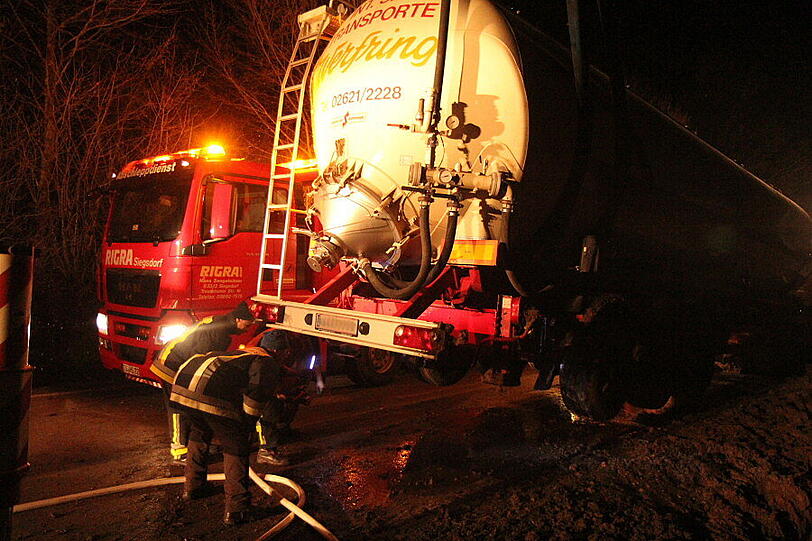 Ein Bergungsfahrzeug und zwei Kräne werden benötigt um den vollbeladenen LKW wieder auf die Straße zu ziehen.