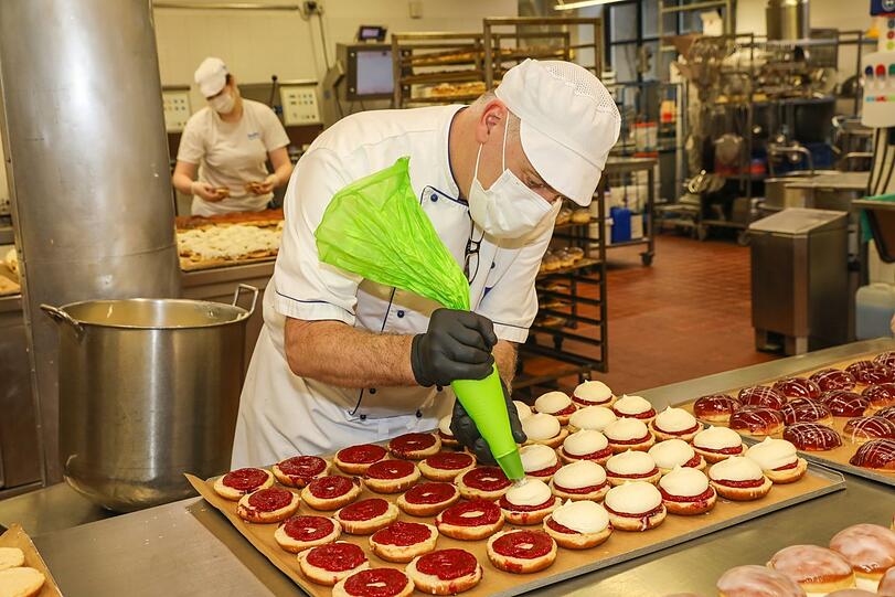 Michael Böttcher versieht jeden einzelnen Krapfen mit einer luftigen Vanillecreme.