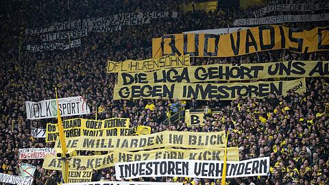 Dortmunds Fans protestieren gegen Investoren im Fußball mit Transparenten mit den Aufschriften: "DFL Hurensöhne", "Die Liga gehört uns ...", "Gegen Investoren", "Die Milliarden im Blick", "Kein Herz fürn Kick", "Investoren verhindern" sowie "Fußball retten".