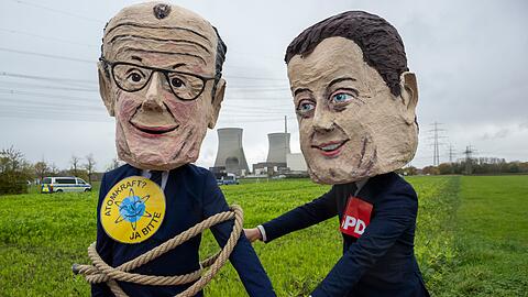 Als Bundeskanzler Friedrich Merz (l) und SPD-Vorsitzender Lars Klingbeil verkleidete Atomkraftbefürworter demonstrieren gegen die Sprengung.