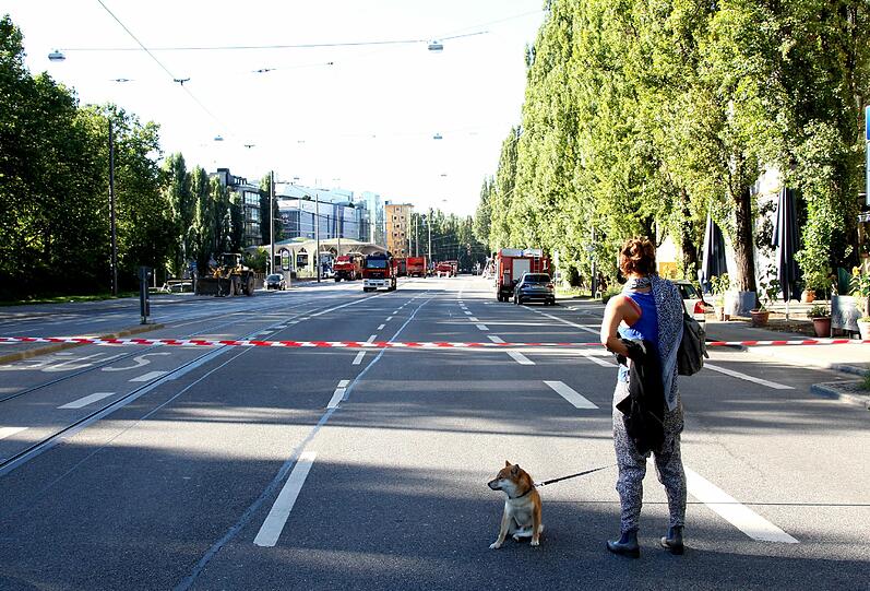 Abgesperrte, menschenleere Leopoldstraße. Eine Frau blickt in Richtung Münchner Freiheit.