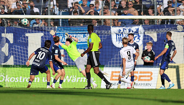Burghausens Benedikt Schwarzensteiner (Nr. 9) erzielt das entscheidende Tor zum 3:1-Endstand, L&ouml;wen-Schlussmann Paul Bachmann streckt sich vergebens.