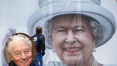 Im Angesicht Ihrer Majestät: Ein Arbeiter hat in Berlin ein XXL-Plakat der Queen angebracht.  Adels-Experte
Rolf Seelmann-Eggebert.