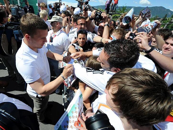 Lukas Podolski schreibt in Eppan fleißig Autogramme.