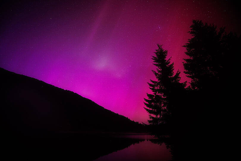 11. Mai 2024 in Krün in Bayern: Polarlichter (Aurora borealis) leuchten am nächtlichen Himmel über dem Wagenbrüchsee.