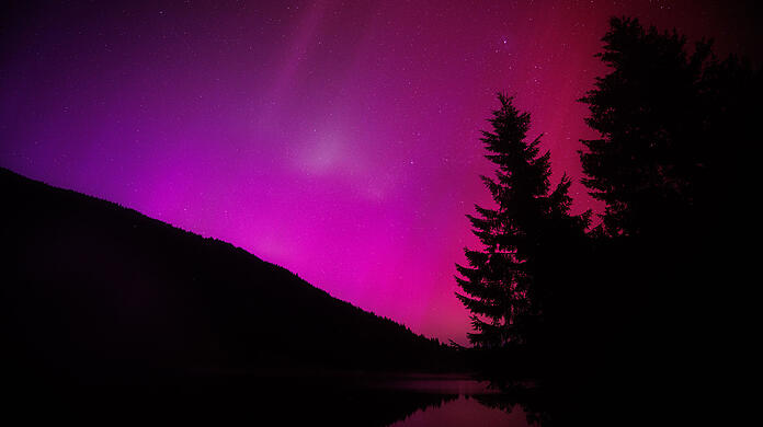 11. Mai 2024 in Krün in Bayern: Polarlichter (Aurora borealis) leuchten am nächtlichen Himmel über dem Wagenbrüchsee.