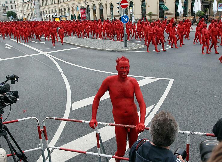 Star-Fotograf Spencer Tunick lässt zur Eröffnung der Opernfestspiele für seine Installation hunderte bunt angemalte Menschen durch München laufen. Das Highlight: Die rot-goldenen Teilnehmer stellen sich an Münchner Monumenten entlang der Ludwigstraße auf. Hier gibts die Bilder!