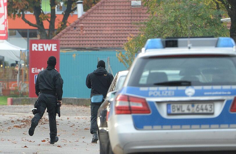 Mit erhobenen Händen kommt ein Mann auf die SEK-Beamten zu, im Hintergrund lauern Heckenschützen der Polizei. Die Beamten nehmen den Mann fest, es ist aber nicht der Täter, der sich in einem Imbiss in Freiburg veschanzt hat.