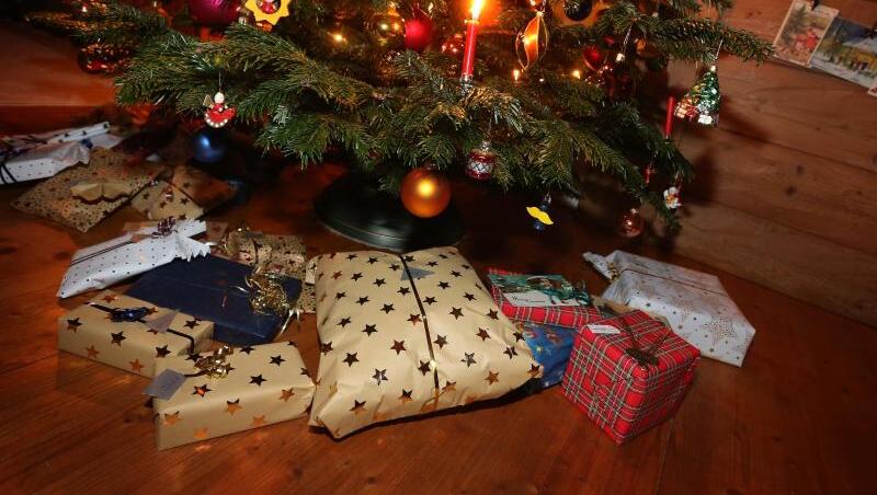 Weihnachtsgeschenke liegen unter einem geschmückten Weihnachtsbaum.