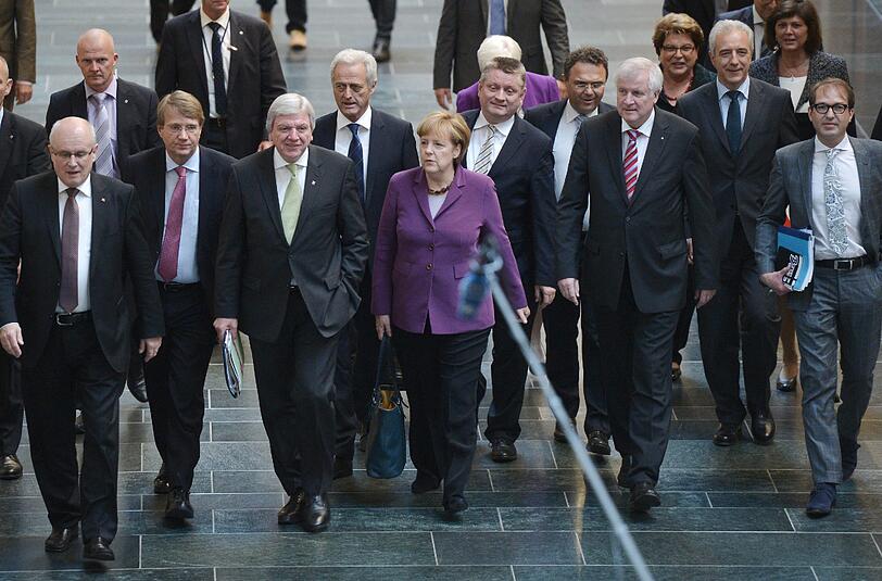 Bundeskanzlerin Angela Merkel (CDU, M.) kommt mit (l-r) Unions-Fraktionschef Volker Kauder, Kanzleramtsminister Ronald Pofalla (CDU), Hessens Ministerpräsident Volker Bouffier (CDU), Verkehrsminister Peter Ramsauer (CSU), CDU-Generalsekretär Hermann Gröhe, Bundesinnenminister Hans-Peter Friedrich (CSU), Sachsens Ministerpräsident Stanislaw Tillich (verdeckt), Bayerns Ministerpräsident Horst Seehofer (CSU), CSU-Generalsekretär Alexander Dobrindt sowie Bayerns Wirtschaftsministerin Ilse Aigner (CSU) am 10.10.2013 in Berlin zu den ersten Sondierungsgesprächen zwischen CDU/CSU und Bündnis 90/Die Grünen.