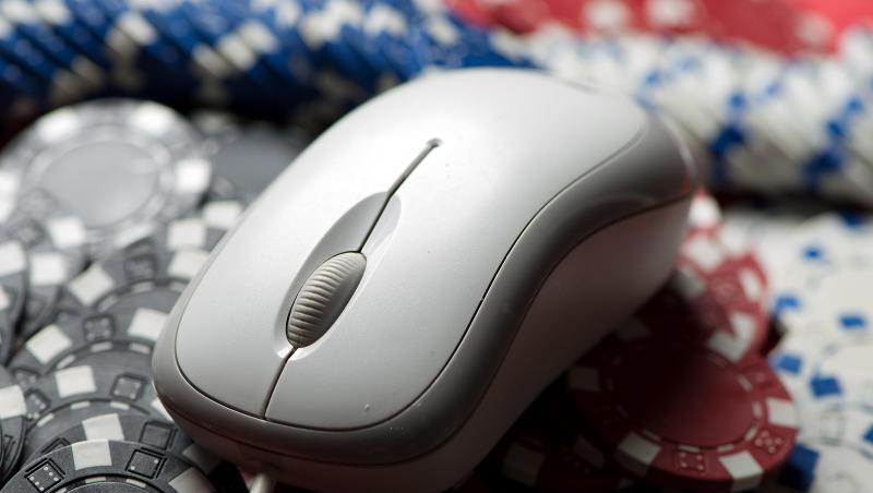 Eine Computermaus liegt auf einem Stapel Glücksspiel-Jetons. Eine Computermaus liegt auf einem Stapel Glücksspiel-Jetons.
