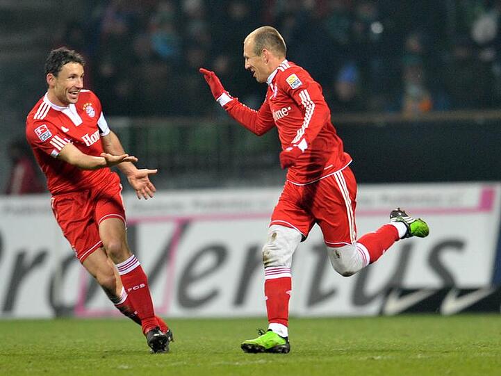 Hand drauf: Bayern-Kapitän Mark van Bommel (l.), hier mit Arjen Robben, verlängert seinen Vertrag.