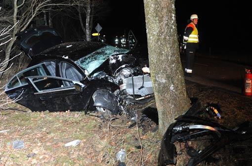 Rettungskräfte stehen am 08.02.2014 bei Biessenhofen (Bayern) neben einem zerstörten Auto.