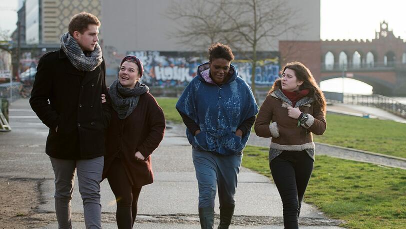 Die Finalisten Andrei Vesa, Charly Ann Schmutzler, Marion Campbell, und Lina Arndt (v.l.) spazieren an der East Side Gallery in Berlin.