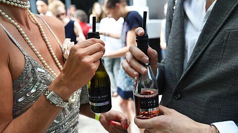 Small Talk mit Prosecco: Gäste unterhalten sich am Rande einer Modenschau in Berlin. (Archivbild)