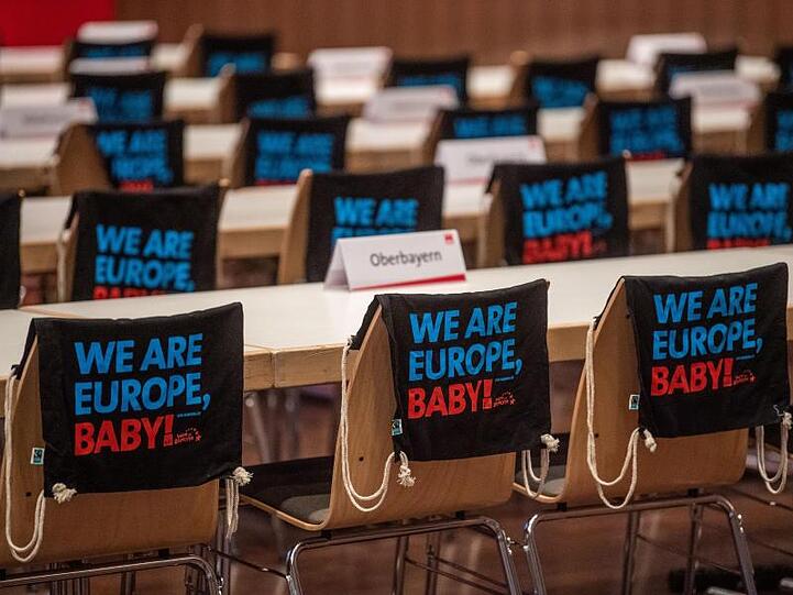 Turnbeutel hängen beim kleinen Parteitag der Bayern-SPD über den Stühlen. Foto: Lino Mirgeler/dpa