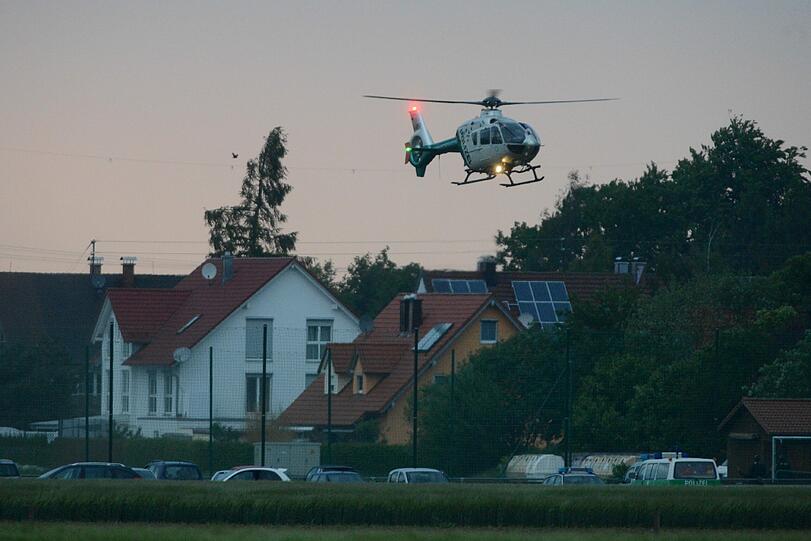 Zwei Jugendliche sitzen vor einem Absperrband an der Zufahrt zur Mittelschule in Memmingen, wo am Mittag Amok-Alarm ausgelöst wurde (Foto vom 22.05.12).
